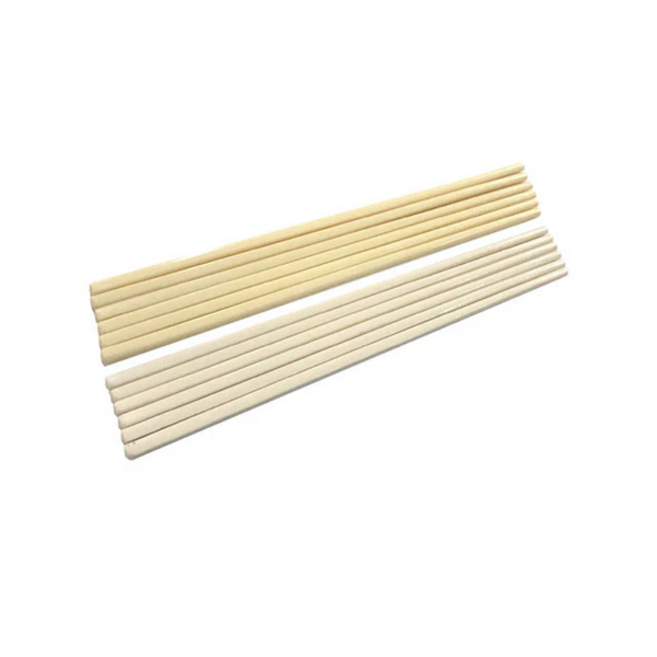 Two sets of white and ivory chopsticks on a white background