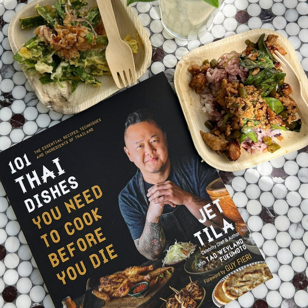 101 Thai Dishes laying on the table next to food found in the book