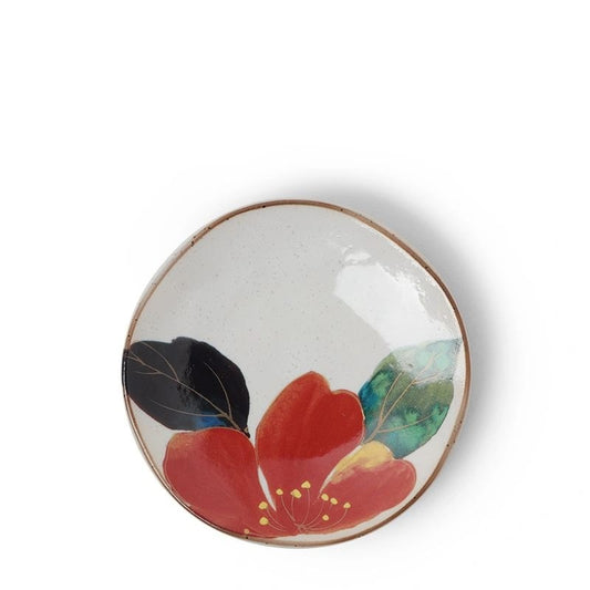 A small ceramic plate with a floral design, predominantly purple and green flowers with a brown rim.