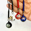 Daruma Bell Charm in black, white, red, and blue