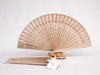 Cream colored wooden fan with organza bag