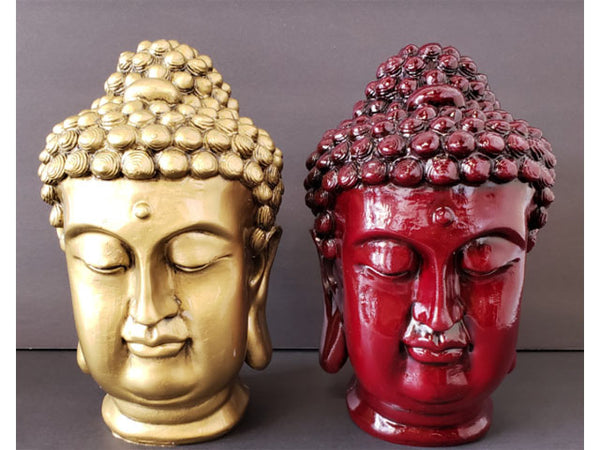 Two Buddha head statues made of resin. One painted in mahogany, the other bronze.
