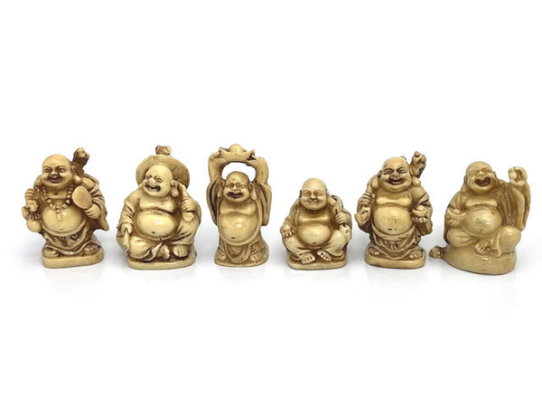 Six laughing buddha. Each in faux ivory and in a different pose