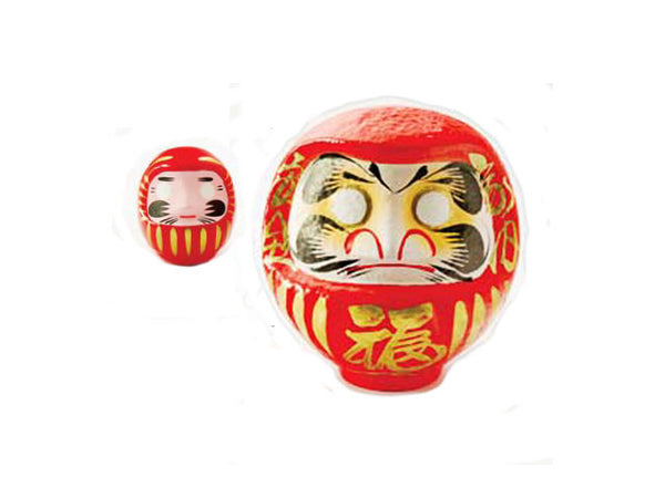 Two red daruma dolls. One is more up close than the other, giving the impression that its bigger