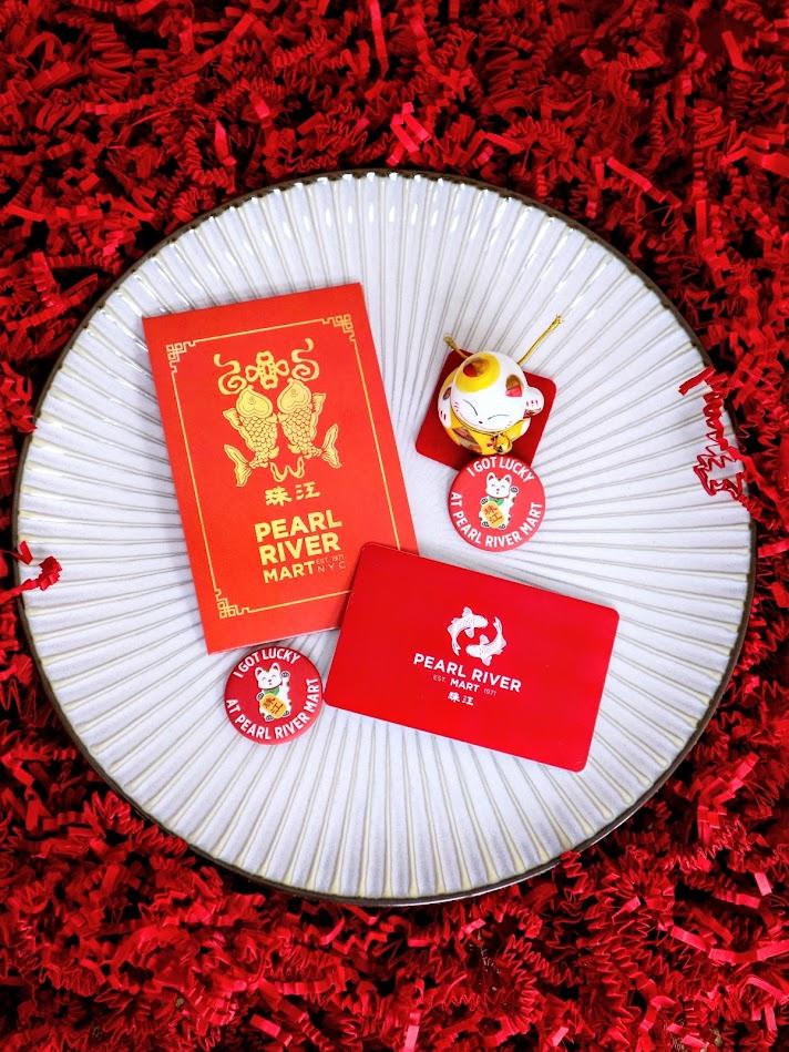 Pearl River Mart gift card with holder and lucky cat on plate