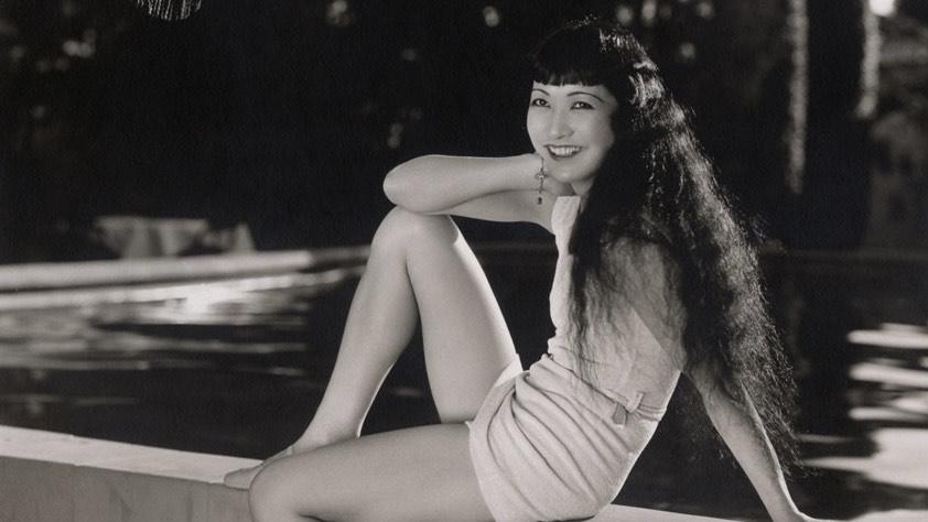 Movie star Anna May Wong lounging poolside