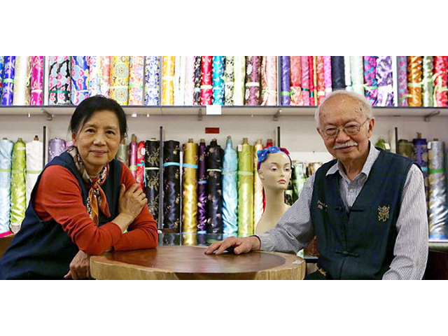 Mr. and Mrs. Chen in front of fabric display at Pearl River Mart