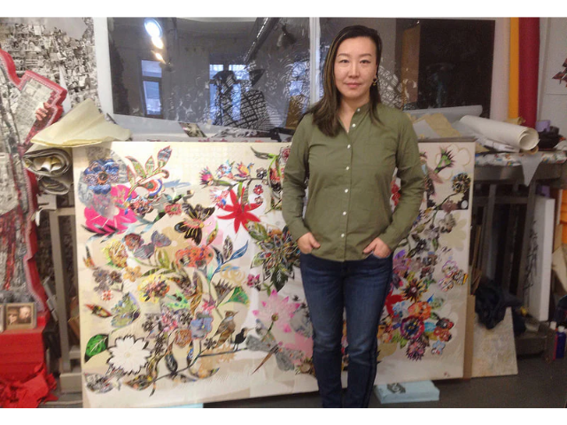 Artist Xin Song in front of one of her pieces in her studio