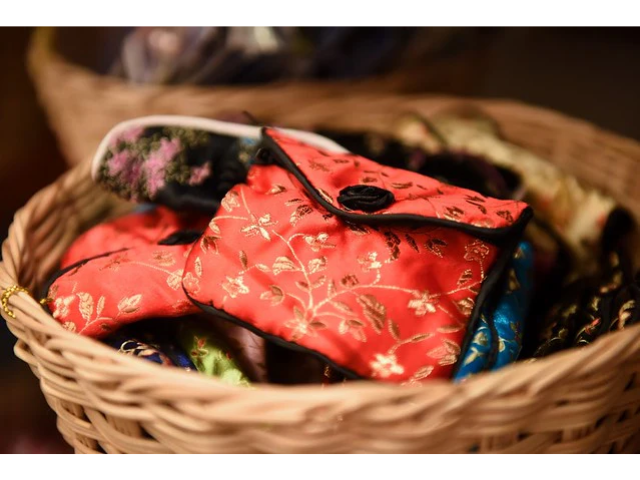 Red brocade coin purse in basket with other brocade coin purses