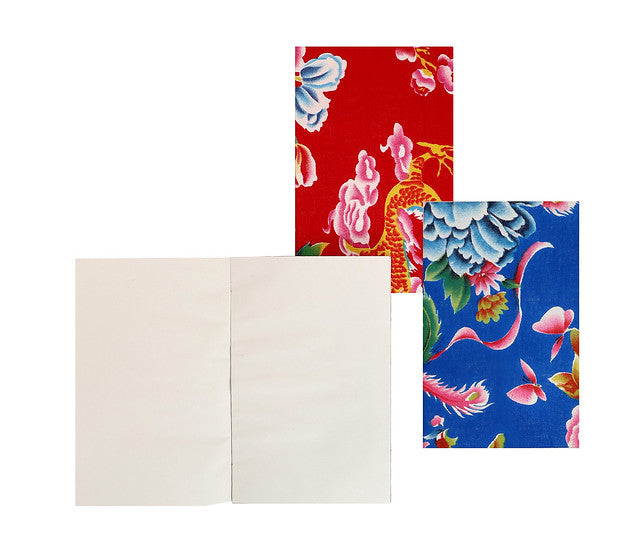 Peony print notebooks in red and blue with notebook open to blank pages