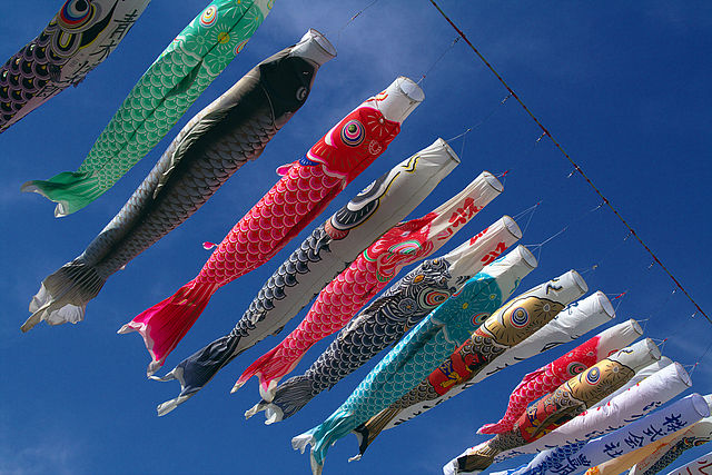 Carp kites on line flying against blue sky