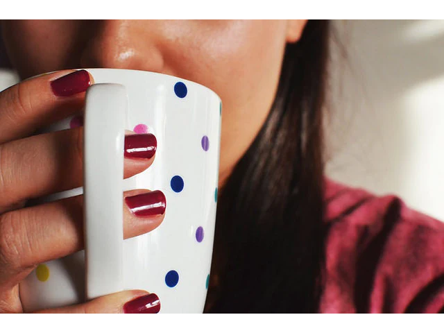 Woman drinking mug of hot tea