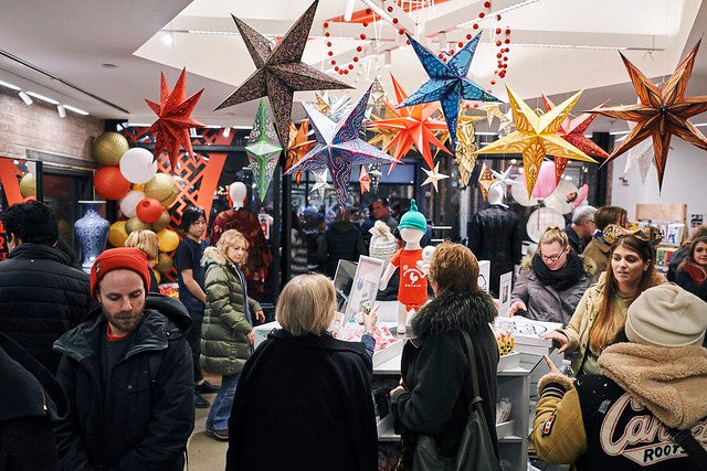 Bustling crowd at Pearl River Mart in Chelsea Market under star ornaments