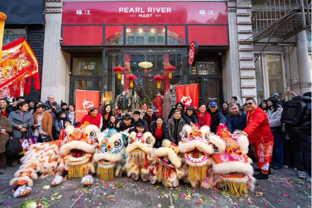 Large group with lion dancers in front of Pearl River Mart in Soho