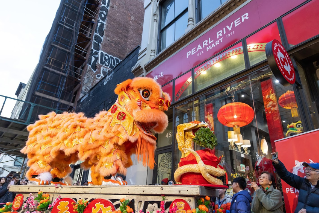Lion dancers on platform in front of Pearl River Mart