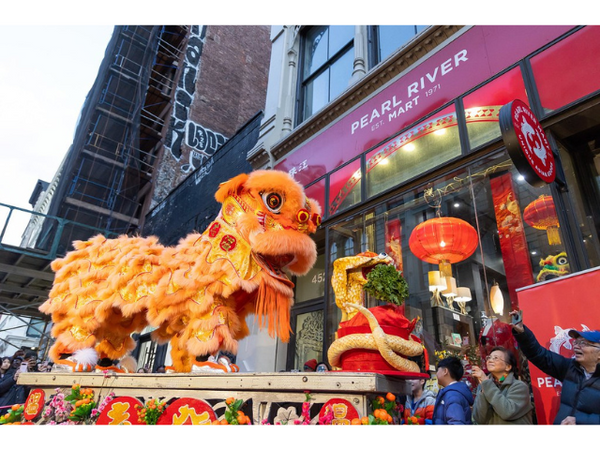 Lion dancer on platform outside Pearl River Mart Soho with owners Mr. and Mrs. Chen