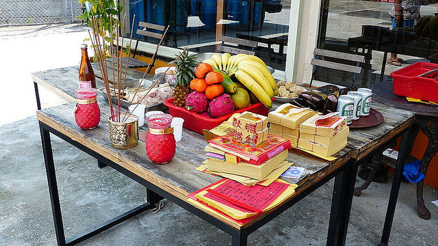Offerings of incense, paper money, and fruit for hungry ghosts