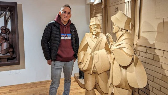 Artist Warren King with his cardboard sculptures of arguing ladies in Pearl River Mart's art gallery