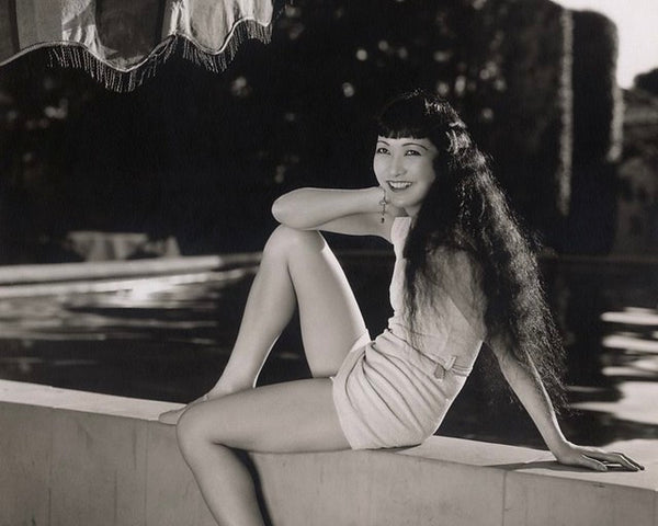 Movie star Anna May Wong lounging poolside
