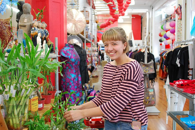 College student Aubri looks at lucky bamboo plants at Pearl River