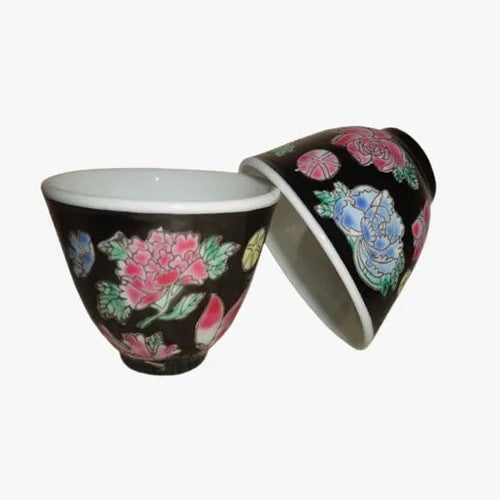 Two black teacups with pink and blue floral pattern