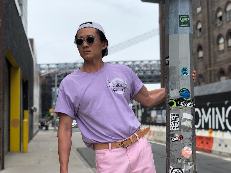 Member of artist collective Bubble_T in purple T-shirt and pink pants on NYC street