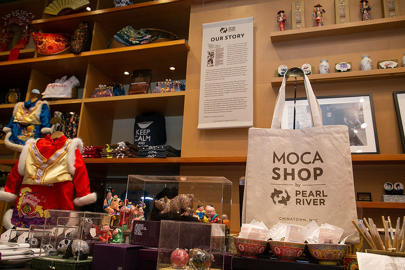 Display at MOCA Shop by Pearl River with tote bag and children's traditional outfit