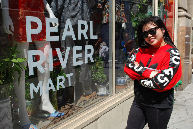 College student Tiffany with sunglasses in front of Pearl River Mart store