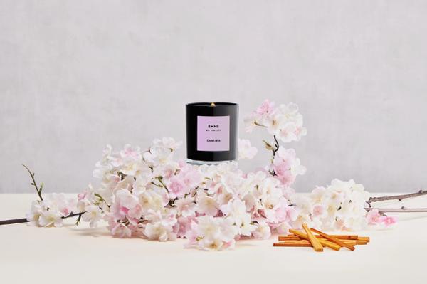 Candle on top of display of pink flowers