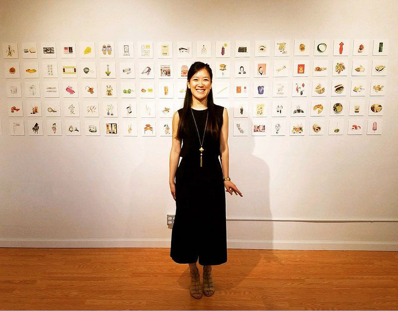 Artist Felicia Liang in front of 100 of her illustrations in the Pearl River Mart gallery in Tribeca