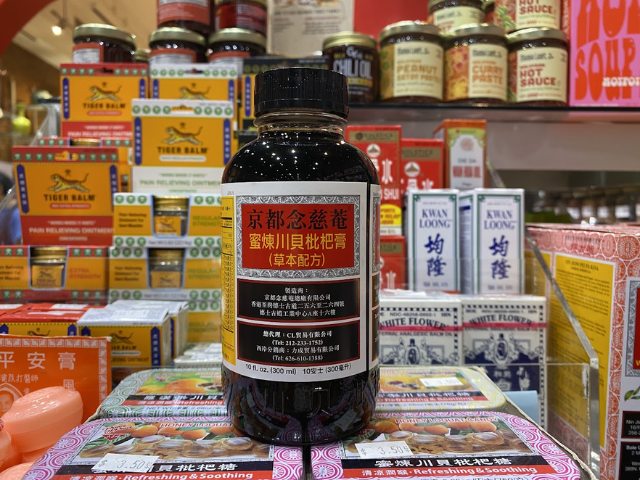 Bottle of honey loquat cough syrup surrounded by traditional Chinese medicines
