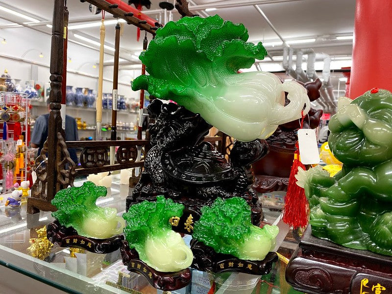 One large and several small cabbage figurines on store shelf