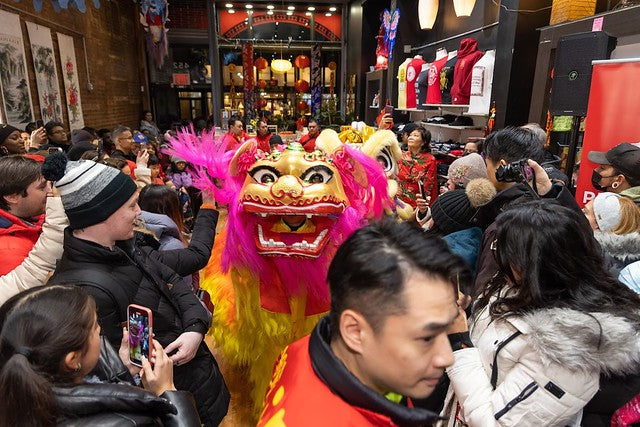 Lion dancer surrounded by crowd in Pearl River Mart