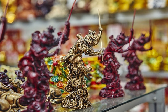 Reddish brown monkey figurines with gold monkey king figurine at center
