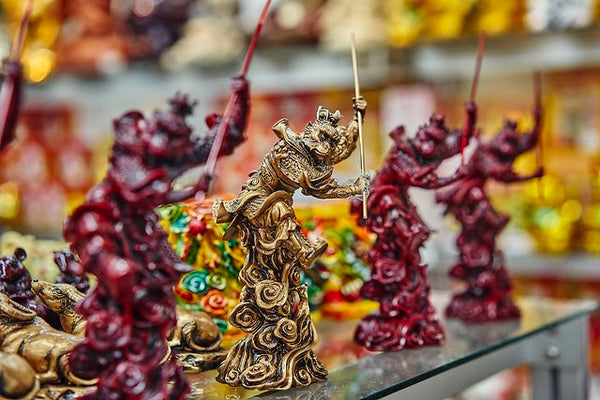 Reddish brown monkey figurines with gold monkey king figurine at center