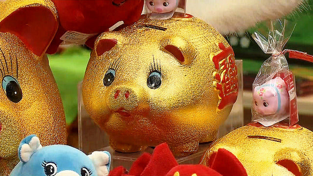 Gold ceramic pig surrounded by other pig figurines