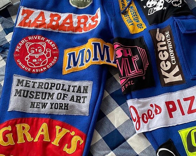 Wearable NYC pride on pants with various logos from iconic NYC institutions
