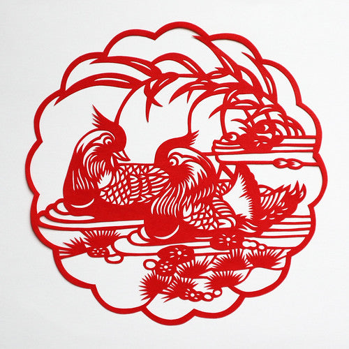 Red Chinese paper cut of two ducks swimming