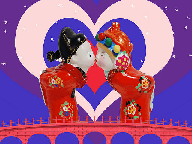 Two Chinese dolls sharing a cute kiss on a bridge