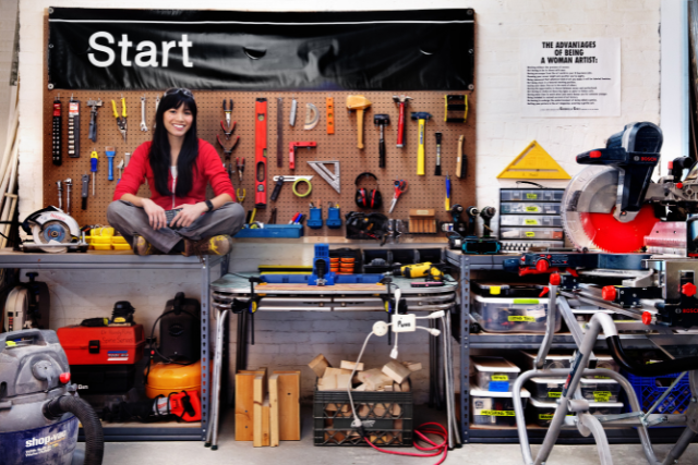 Artist Risa Puno in her workshop surrounded by tools and books