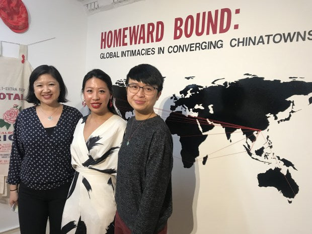 Pearl River Mart President Joanne Kwong and artists Diane Wong and Huiying B. Chan in front of map from Homeward Bound exhibition in the Pearl River Mart gallery