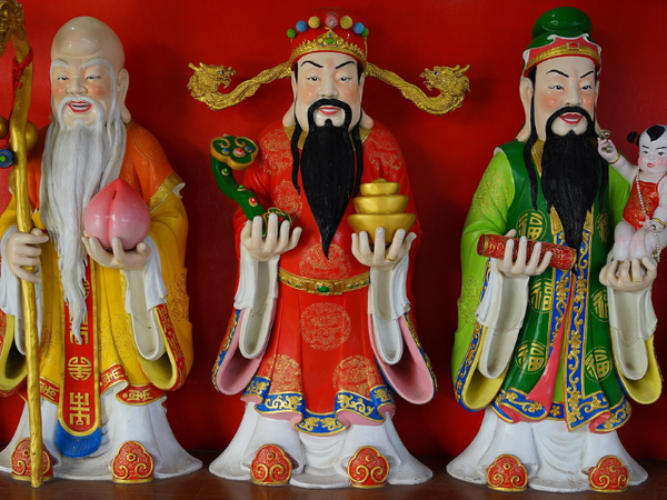 Three colorful figurines representing Chinese dieities