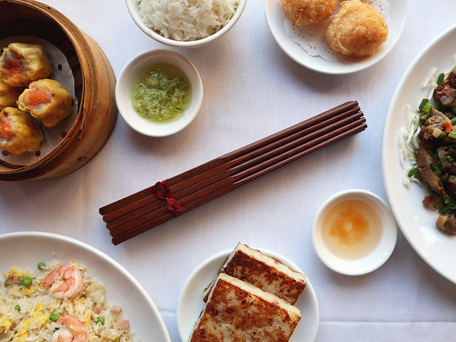 Set of 10 chopsticks on table surrounded by dim sum