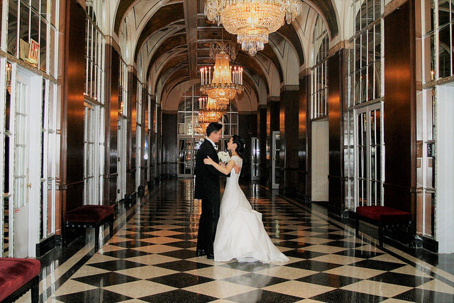 Bride and groom in hallway under chandelier