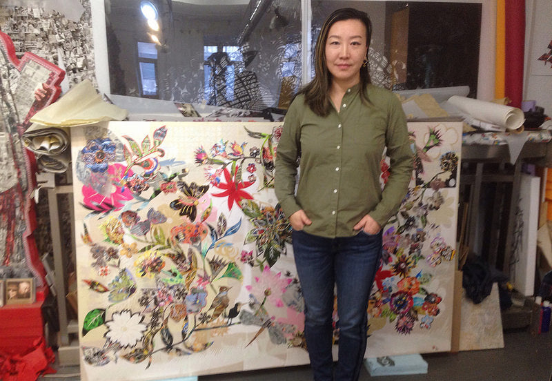 Artist Xin Song in front of one of her pieces in her studio