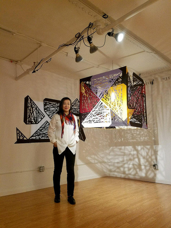 Artist Xin Song with her hanging papercut cube in the Pearl River Mart gallery in Tribeca