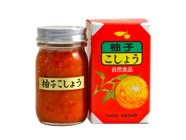 Jar of red yuzu kosho beside box with orange and Japanese characters