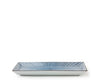A rectangular ceramic serving platter with a blue and white sunburst pattern on the top, shown against a plain white background.