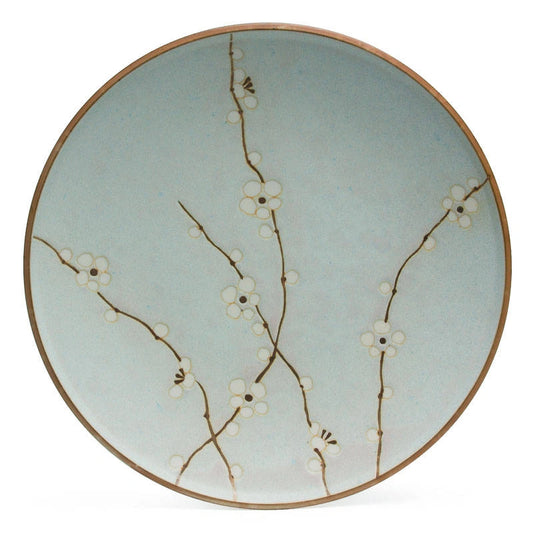 A round ceramic plate with a pale blue-green glaze, decorated with delicate brown branches and small white blossoms, finished with a thin brown rim, shown against a plain white background.