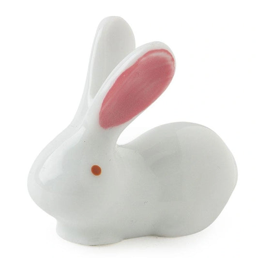 White ceramic rabbit figurine with pink inner ears on a white background